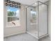 Bathroom with a glass enclosed shower that has grey marbled walls and a view outside of the window at 7101 Short Stirrup Ln, Mint Hill, NC 28227