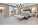 Neutral primary bedroom with a decorative chandelier and a large window to let in plenty of light at 7101 Short Stirrup Ln, Mint Hill, NC 28227