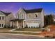 Charming two-story home with gray siding, a front porch, and an attached two-car garage at 7101 Short Stirrup Ln, Mint Hill, NC 28227