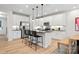 Modern kitchen features white cabinets, stainless steel appliances, a center island with bar stools, and pendant lighting at 7101 Short Stirrup Ln, Mint Hill, NC 28227