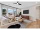 Bright living room with a large sectional sofa, modern lighting, and expansive windows at 7101 Short Stirrup Ln, Mint Hill, NC 28227