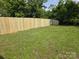 Large grassy backyard surrounded by a tall wooden fence, providing privacy and security at 76 Sumner Nw Ave, Concord, NC 28027