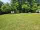 Large backyard featuring a grassy area and a small outbuilding at 76 Sumner Nw Ave, Concord, NC 28027