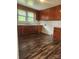 Kitchen with wooden cabinets, sink with window, and wood-style flooring at 76 Sumner Nw Ave, Concord, NC 28027