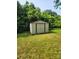Storage shed in backyard, surrounded by lush greenery at 76 Sumner Nw Ave, Concord, NC 28027