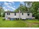 Exterior view of a home with a green lawn, mature trees, and a utility shed in the back at 8334 Oaktree Rd, Sharon, SC 29742