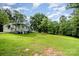 Exterior view of a home with a green lawn and mature trees creating a serene backdrop at 8334 Oaktree Rd, Sharon, SC 29742