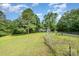 Exterior view of a home with a green lawn and mature trees creating a serene backdrop at 8334 Oaktree Rd, Sharon, SC 29742