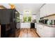Well-lit kitchen boasts white cabinets, modern appliances, and wood flooring at 8334 Oaktree Rd, Sharon, SC 29742