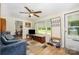 Inviting living room with a ceiling fan, plush blue sofa, and bright windows at 8334 Oaktree Rd, Sharon, SC 29742