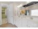 Bright bathroom featuring a double vanity, decorative mirror, and open closet at 8725 Soaring Eagle Ln, Waxhaw, NC 28173