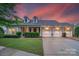 Charming brick home featuring a three-car garage, dormer windows, and professionally landscaped yard at 8725 Soaring Eagle Ln, Waxhaw, NC 28173