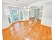 Bright dining room featuring hardwood floors, large windows, wainscotting and a modern chandelier at 8803 Sweetwater Pl, Waxhaw, NC 28173