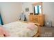 Bright bedroom features light colored walls and a wood framed bed and dresser at 9805 Coatbridge Dr, Charlotte, NC 28269