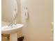 Simple powder room with a pedestal sink, decorative mirror, and neutral color scheme at 1003 Silver Spring Rd, Fort Mill, SC 29715