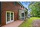 Exterior backyard view with brick facade, patio, screened in porch and lush lawn at 1035 Wexford Nw Pl, Concord, NC 28027