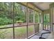 Enjoy nature views from this screened porch with large windows showcasing the surrounding greenery and wooded landscape at 1035 Wexford Nw Pl, Concord, NC 28027