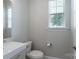 Clean half bathroom featuring a white vanity, modern toilet, and a bright window at 1211 Gold Rush Ct, Fort Mill, SC 29708