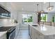Bright kitchen boasts white quartz countertops, shaker cabinets, stainless appliances, and a large island with counter seating at 1211 Gold Rush Ct, Fort Mill, SC 29708