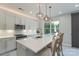 Beautiful kitchen features an island with seating, stainless steel appliances, quartz countertops, and backyard views at 1211 Gold Rush Ct, Fort Mill, SC 29708
