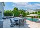 A view of the travertine patio with furniture and the in-ground pool at 1211 Gold Rush Ct, Fort Mill, SC 29708