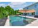 A view of the in-ground pool, travertine patio, and the home's exterior at 1211 Gold Rush Ct, Fort Mill, SC 29708