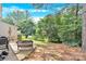 View of a backyard featuring a patio set and well-maintained landscaping with mature trees providing ample shade at 125 Lynch Cir, Mooresville, NC 28117