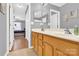 Bathroom featuring a mirror, double sinks, tan cabinets, a toilet, and a shower with gray curtains at 125 Lynch Cir, Mooresville, NC 28117