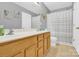 Bathroom featuring a mirror, double sinks, tan cabinets, a toilet, and a shower with gray curtains at 125 Lynch Cir, Mooresville, NC 28117