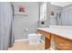 This bathroom has a shower with gray curtains, a toilet, a large mirror, and a sink with tan cabinets at 125 Lynch Cir, Mooresville, NC 28117