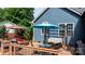 Relax on this spacious backyard deck featuring a swing, lounge seating, and umbrella at 1305 Creekview Dr, Gastonia, NC 28052