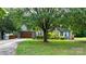 Inviting home exterior featuring a well-manicured lawn, mature trees, and a charming facade with a brick and siding combination at 1305 Creekview Dr, Gastonia, NC 28052