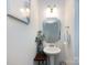 Small bathroom with a pedestal sink, decorative mirror, and modern lighting creating a charming powder room at 13422 Calloway Glen Dr, Charlotte, NC 28273