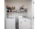 Functional laundry room with modern washer and dryer units, and ample shelving for storage at 13422 Calloway Glen Dr, Charlotte, NC 28273