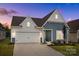 Charming two-story home featuring blue and white siding, attached two-car garage, and well-maintained landscaping at 161 Pampas Pl, Statesville, NC 28625