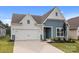Charming two-story home featuring blue and white siding, attached two-car garage, and well-maintained landscaping at 161 Pampas Pl, Statesville, NC 28625
