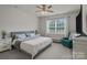 Spacious bedroom with neutral tones, large window, ceiling fan, and comfortable sitting area at 161 Pampas Pl, Statesville, NC 28625