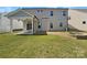 Spacious backyard featuring a covered patio, stone fire pit, manicured lawn and a light gray exterior at 163 W Heart Pine Ln, Statesville, NC 28677