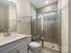 Bathroom showcasing a glass enclosed shower with tiled walls and a built-in seat at 163 W Heart Pine Ln, Statesville, NC 28677