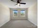 Bedroom with carpet, neutral walls, and two windows overlooking the green backyard at 163 W Heart Pine Ln, Statesville, NC 28677