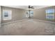 Spacious bedroom featuring neutral walls, plush carpet, a ceiling fan, and an abundance of natural light from multiple windows at 163 W Heart Pine Ln, Statesville, NC 28677
