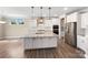 Modern kitchen features a large island, stainless steel appliances, double ovens, and recessed lighting at 163 W Heart Pine Ln, Statesville, NC 28677