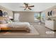 This staged main bedroom provides a calm atmosphere with two windows, a ceiling fan, and soothing beige carpet at 163 W Heart Pine Ln, Statesville, NC 28677