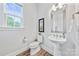 Half bathroom featuring new floors, a pedestal sink, and natural light at 1702 Batson Creek Ln, Weddington, NC 28104