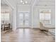 Bright foyer features wood floors, elegant glass doors, and natural light streaming in through the windows at 1702 Batson Creek Ln, Weddington, NC 28104