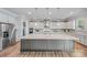 Modern kitchen features an oversized island with granite countertops, stainless steel appliances, and custom white cabinetry at 1702 Batson Creek Ln, Weddington, NC 28104