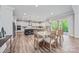 Bright open-plan kitchen and dining area with stainless appliances and wood flooring at 1702 Batson Creek Ln, Weddington, NC 28104
