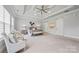 This is a main bedroom with a tray ceiling, ceiling fan, sitting area, and sliding barn doors for closet access at 1702 Batson Creek Ln, Weddington, NC 28104
