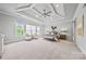 This is a main bedroom with a tray ceiling, ceiling fan, sitting area, and large windows that provide ample natural light at 1702 Batson Creek Ln, Weddington, NC 28104
