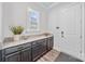 Mudroom with granite counters, dark cabinets, adjacent to exterior door and window at 1702 Batson Creek Ln, Weddington, NC 28104
